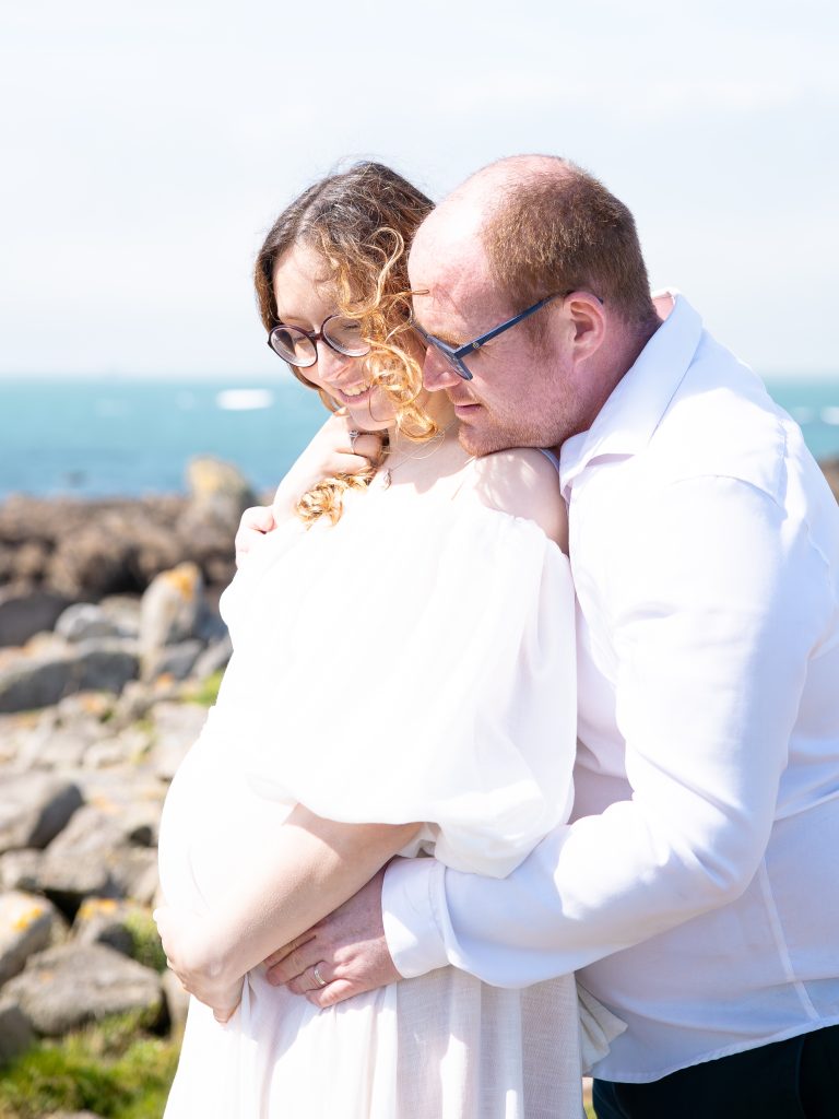 un couple de futurs parents pendant la séance photos grossesse à la plage de guisseny